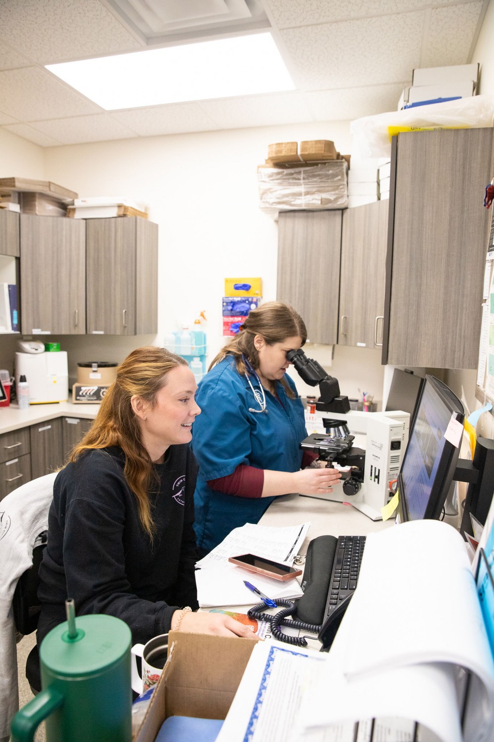Staff reviewing sample on microscope